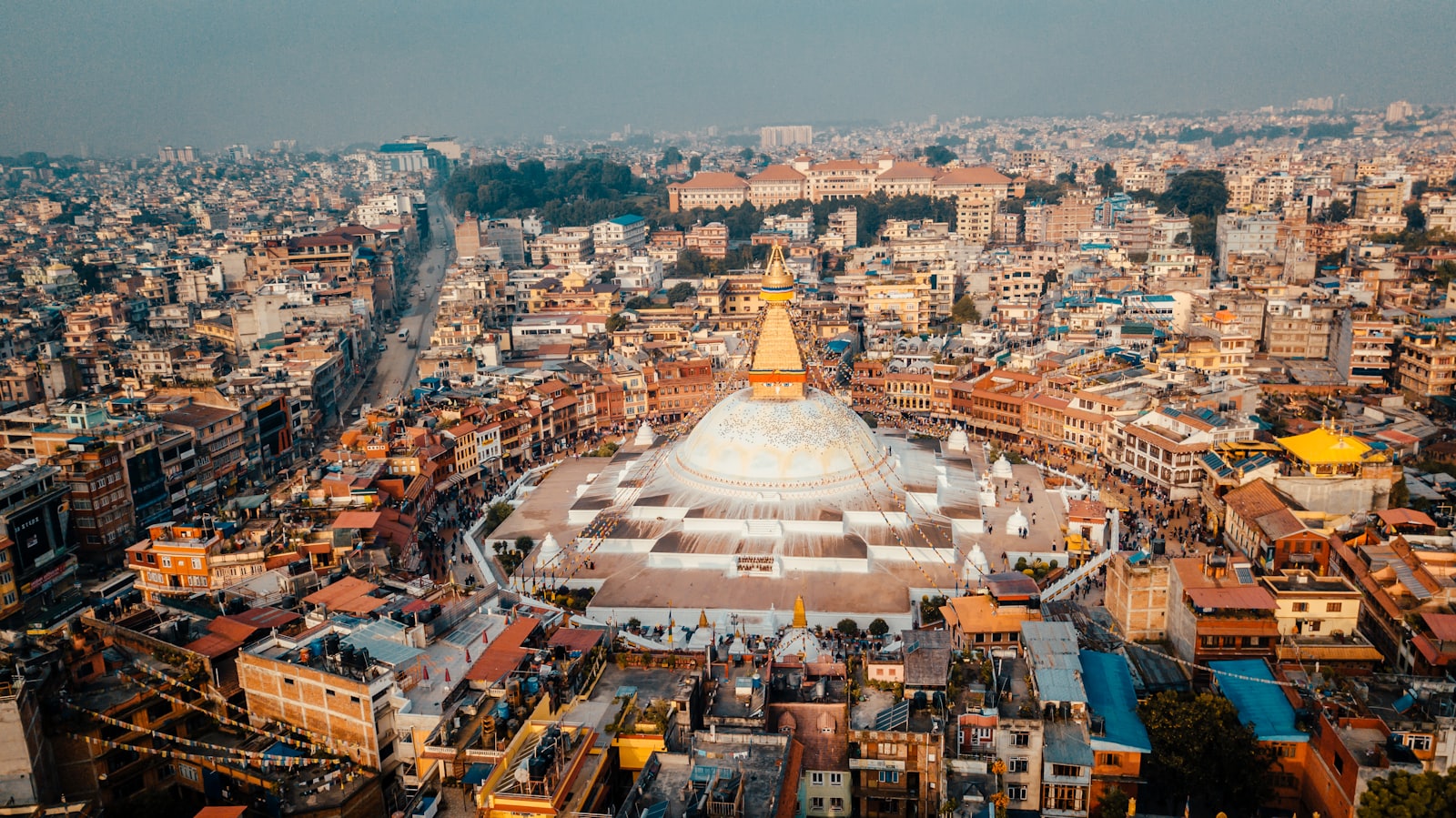 Boudhanath Stupa rising above the rooftops of Kathmandu at dusk